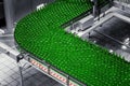 Automated conveyor line in a brewery. Rows of green glass bottles on a conveyor belt. Royalty Free Stock Photo