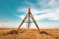 Automated farming irrigation machinery with sprinklers in barley field