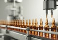 Automated filling machine dispensing amber vials on a production line Royalty Free Stock Photo