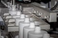 Automated production line for casting white plastic bottles. White plastic bottles on a production line. Molding of