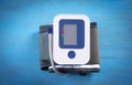 Automatic blood pressure meter on blue background Royalty Free Stock Photo