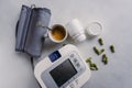 Automatic blood pressure meter with pills and coffee Royalty Free Stock Photo