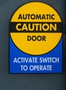 Automatic caution door sign. Automatic glass doors with yellow sign Caution