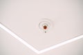 Automatic ceiling fire sprinkler system on white ceiling.