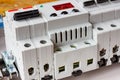 Automatic circuit breakers and voltage limiter installed on DIN rail in the white plastic mounting box closeup Royalty Free Stock Photo