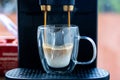 Automatic coffee machine brewing espresso into glass cup Royalty Free Stock Photo