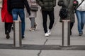 Automatic cylindrical barriers on the pedestrian zone against the background of blurry feet of pedestrians