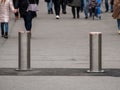 Automatic cylindrical barriers on the pedestrian zone against the background of blurry feet of pedestrians