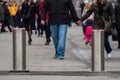 Automatic cylindrical barriers on the pedestrian zone against the background of blurry feet of pedestrians