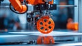 Automatic 3d printer creating orange plastic wheel in laboratory Royalty Free Stock Photo