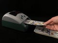 Automatic detector for checking banknotes. Dollars are checked through the device. One hundred dollar bills and a machine for Royalty Free Stock Photo