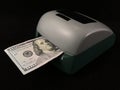Automatic detector for checking banknotes. Dollars are checked through the device. One hundred dollar bills and a machine for Royalty Free Stock Photo