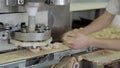 Automatic dispenser forms pieces from dough in bakery indoors.