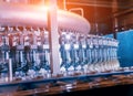 Automatic filling machine pours water into plastic PET bottles. Royalty Free Stock Photo