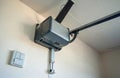 Automatic garage door opener motor system mounted on wall, ceiling inside residential garage. Modern electric device control Royalty Free Stock Photo
