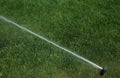 Automatic Garden Lawn sprinkler in action watering green grass Royalty Free Stock Photo