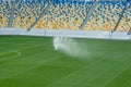 Automatic lawn grass watering system at the stadium. A football, soccer field in a small provincial town. Underground sprinklers Royalty Free Stock Photo