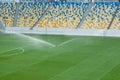 Automatic lawn grass watering system at the stadium. A football, soccer field in a small provincial town. Underground sprinklers Royalty Free Stock Photo