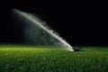 Automatic lawn sprinkler spraying water over golf course green grass Royalty Free Stock Photo