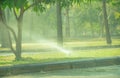Automatic lawn sprinkler watering green grass on sunny summer days. Sprinkler with automatic system. Garden irrigation system Royalty Free Stock Photo