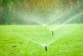 Automatic lawn sprinkler watering green grass. Sprinkler with automatic system. Garden irrigation system watering lawn. Water Royalty Free Stock Photo