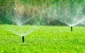 Automatic lawn sprinkler watering green grass. Sprinkler with automatic system. Garden irrigation system watering lawn. Water Royalty Free Stock Photo