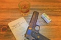 Automatic pistol with antique document and whiskey.