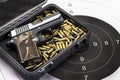 Automatic pocket gun and bullets in box on bull eye target background Royalty Free Stock Photo