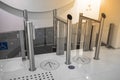 Automatic silver metallic security turnstile station against white tile floor