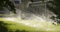 Automatic sprinkler system watering the lawn on a background of green grass Royalty Free Stock Photo