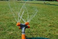 Automatic sprinkler system watering the lawn on a background of green grass, close-up Royalty Free Stock Photo