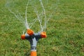 Automatic sprinkler system watering the lawn on a background of green grass, close-up Royalty Free Stock Photo