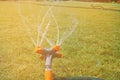 Automatic sprinkler system watering the lawn on a background of green grass, close-up Royalty Free Stock Photo