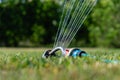 Automatic sprinkler system watering the lawn on a background of green grass Royalty Free Stock Photo