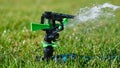 Automatic sprinkler system watering the lawn on a background of green grass Royalty Free Stock Photo