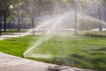 Automatic sprinklers watering grass. Garden Watering Systems. Irrigation System Watering the green grass Royalty Free Stock Photo