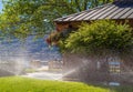 Automatic sprinklers watering grass. Garden Watering Systems. Irrigation System Watering the green grass Royalty Free Stock Photo