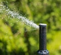 Automatic sprinklers watering grass. Garden Watering Systems. Irrigation System Watering the green grass Royalty Free Stock Photo