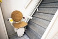 Automatic stair lift on staircase taking elderly people and disabled persons up and down in a house