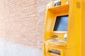 Automatic Teller Machine ATM. Yellow cash box is located next to the brick wall. To use all services. as background finance con Royalty Free Stock Photo