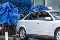 Automatic wash blue brush in action, white car comes out ready clean