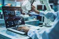 Automation engineer programming robotic arm at factory for automatic manufacturing industry