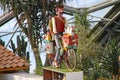 An automaton delivery man rides a bicycle in a biome at the Eden Project in Cornwall, England Royalty Free Stock Photo