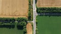 Automobile asphalt road with cars driving along it between agricultural fields