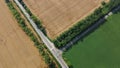 Automobile asphalt road with cars driving along it between agricultural fields Royalty Free Stock Photo