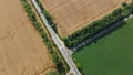 Automobile asphalt road with cars driving along it between agricultural fields