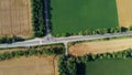 Automobile asphalt road with cars driving along it between agricultural fields