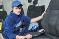 automobile detailing. Portrait of worker during car seat cleaning with vacuum cleaner Royalty Free Stock Photo