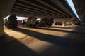 Automobile concrete mixers under a car overpass with beautiful sunset lighting and long shadows