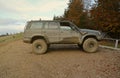 Automobile in a countryside landscape with a mud road. Off-road 4x4 suv automobile with ditry body after drive in muddy Royalty Free Stock Photo